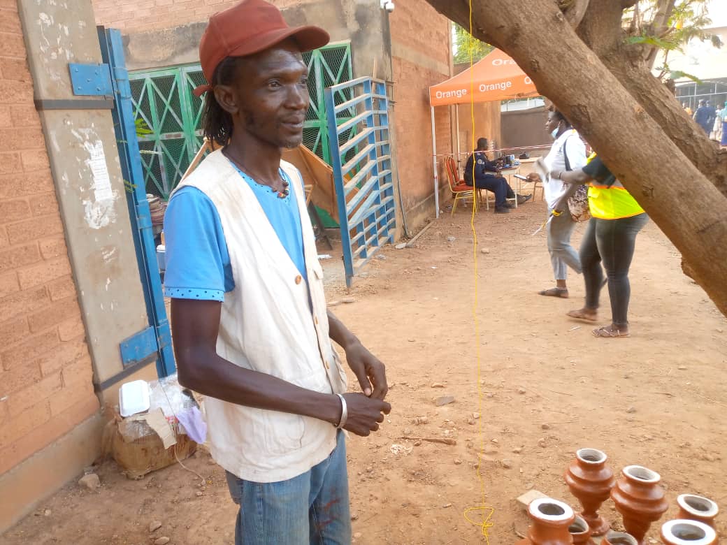 Amperral Ahouangonou, devant ses pots de fleurs 